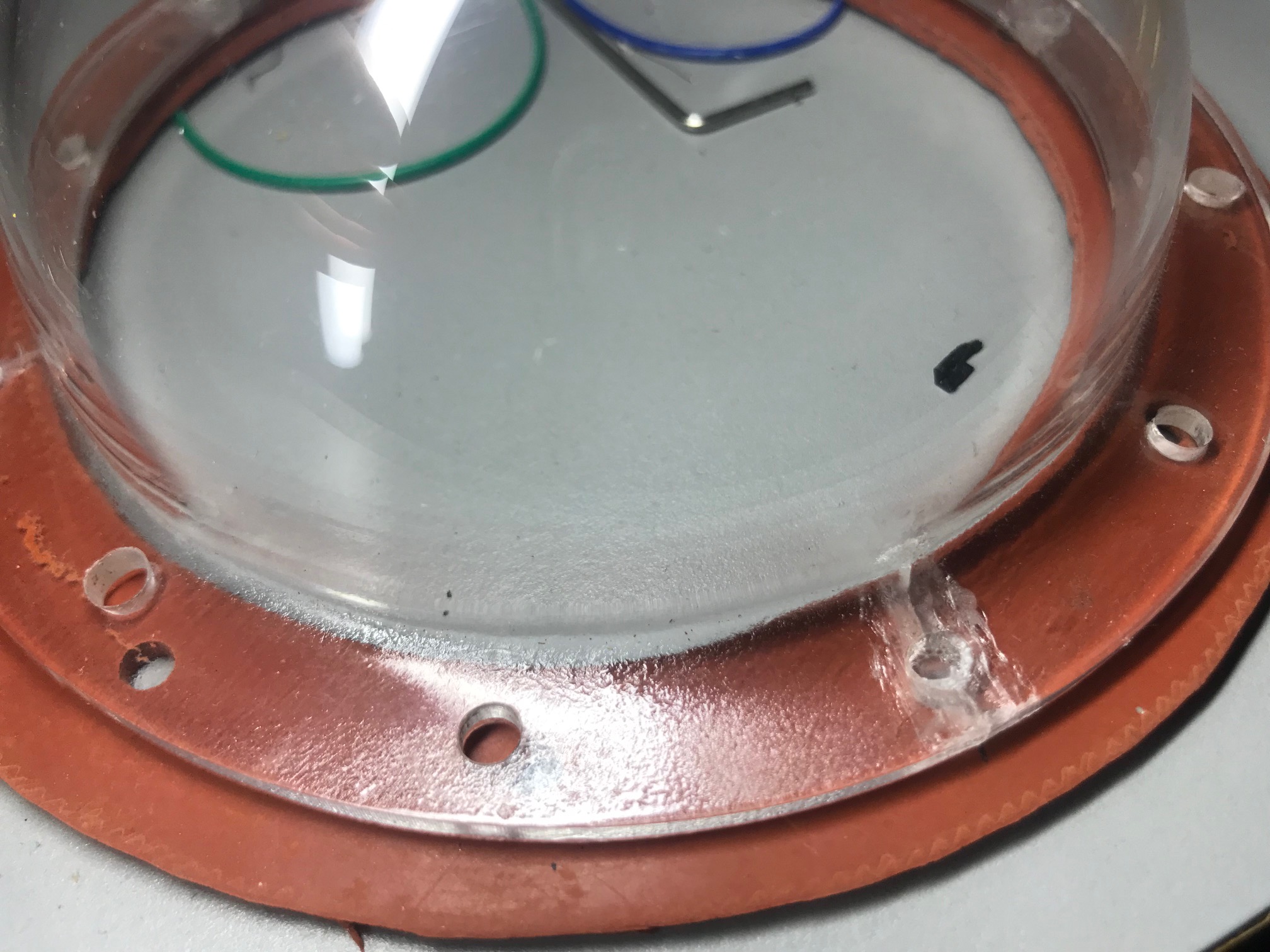 Lens cap.  Note the cracks where I drilled the new holes.  I tried "gluing" it back together with a special acrylic glue.