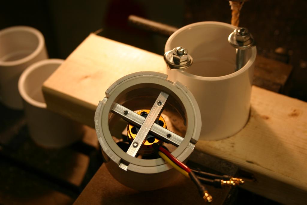 In this photo you can see the motor housing being milled. I made the jig in the photo to clamp the 2" PVC pipe coupling while it was being milled. The slots are .25" wide and were milled .600 deep. This allowed the .25" motor supports to be pushed in and then a .35" thick slice from a 2" PVC pipe was installed to hold the motor supports in place.